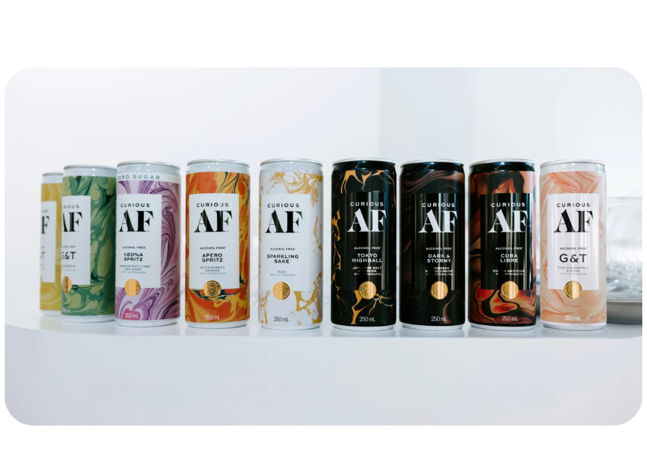 Several cans of Curious AF, a non-alcoholic beverage by AF Drinks, lined up on a shelf