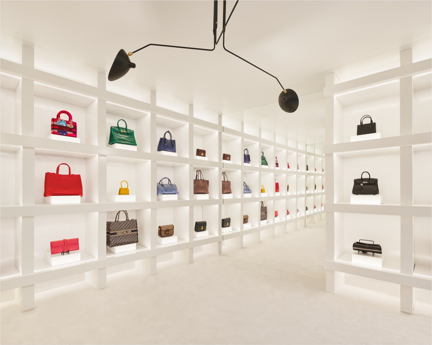 A collection of luxury handbags on display, including a prominently featured Dior bag, representing The RealReal's commitment to authenticity and sustainable fashion.