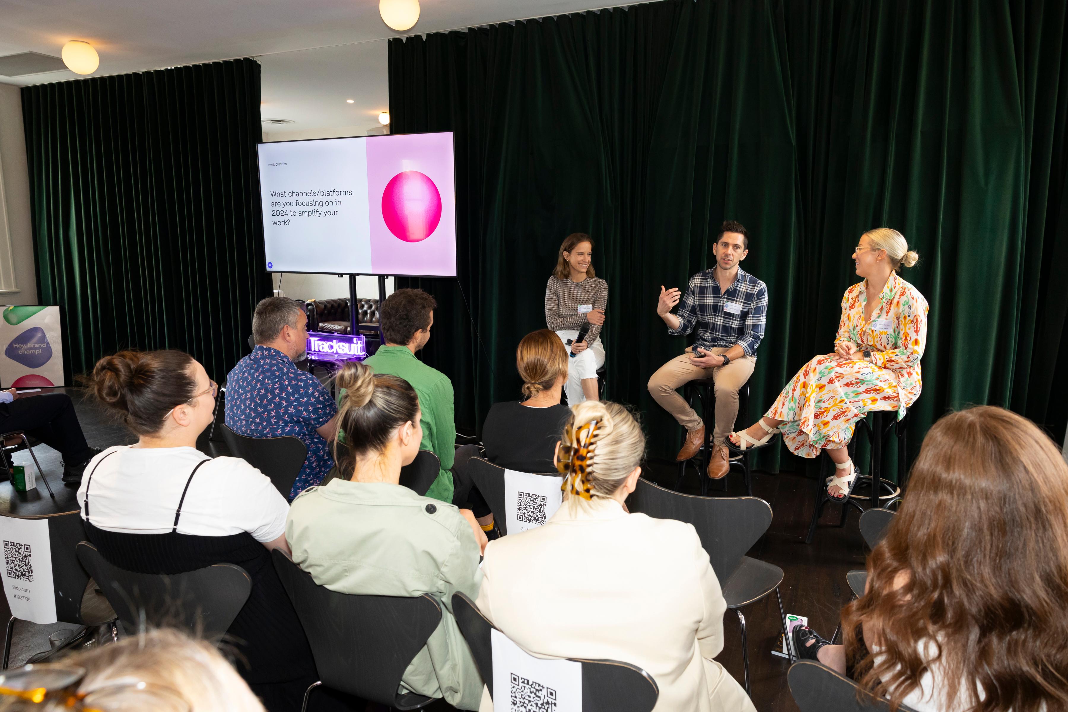 A group of marketing professionals discussing strategies at a Tracksuit event