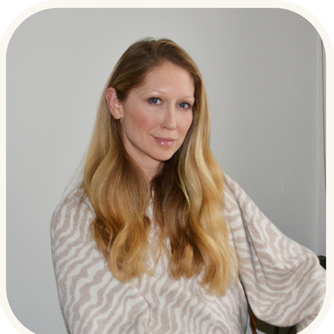 A stylish woman with long blonde hair wearing a zebra print sweater