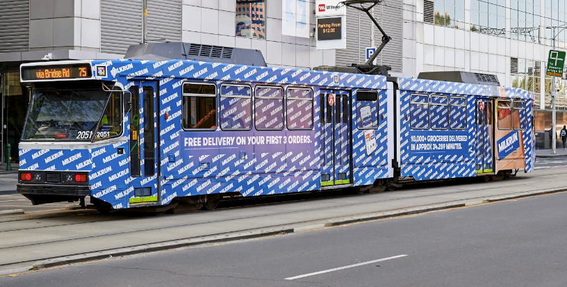 A tram advertising MILKRUN's offer of free delivery on the first two orders, promoting the brand's ultra-fast grocery delivery service in Australia.