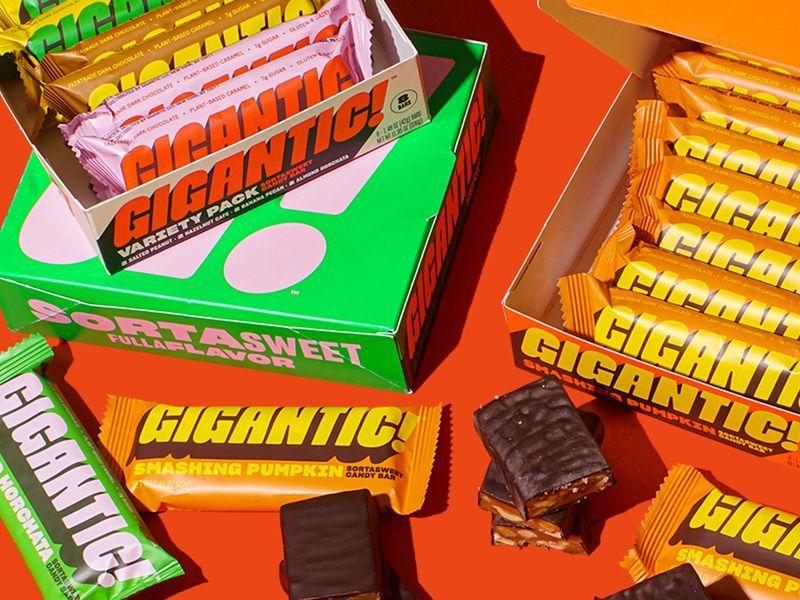 A stack of oversized candy bars in a box displayed on a table, representing the consumer packaged goods industry