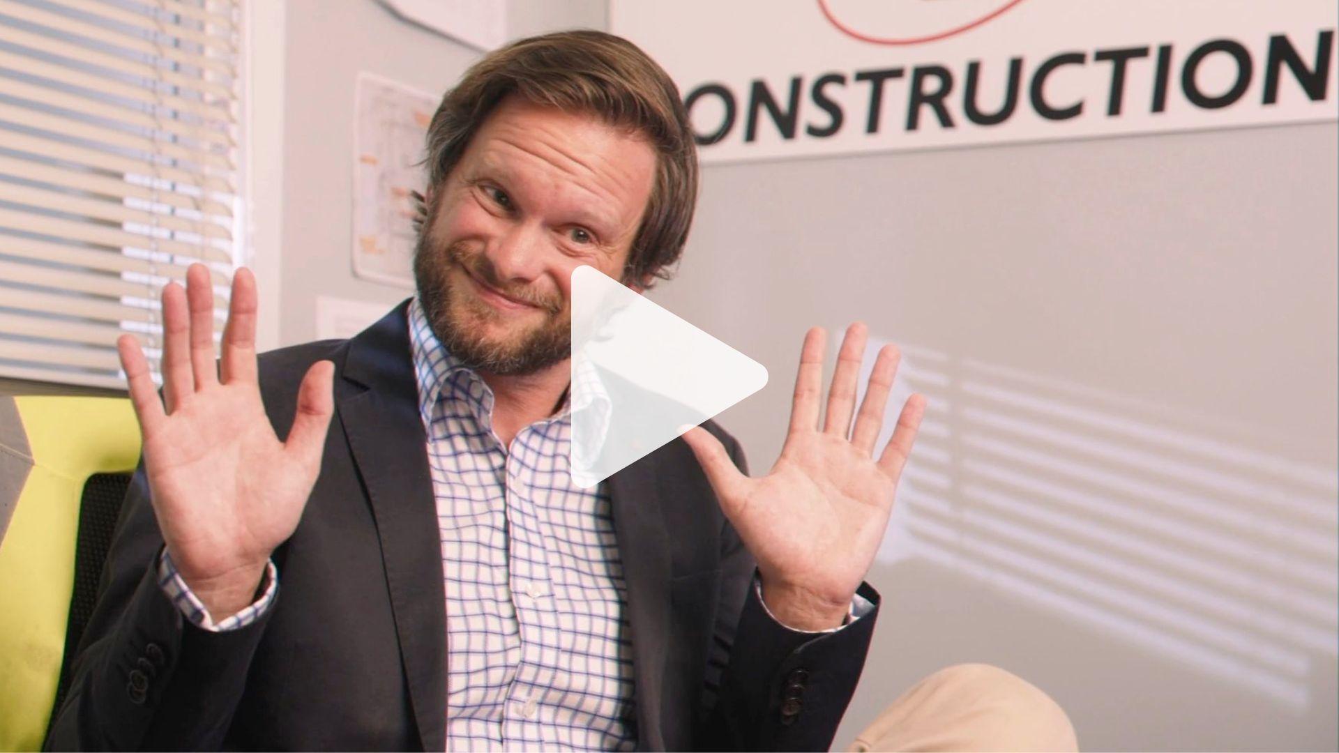 A professional man in a suit sitting in front of a construction sign, symbolizing the concept of building a unique brand voice in the context of the article.