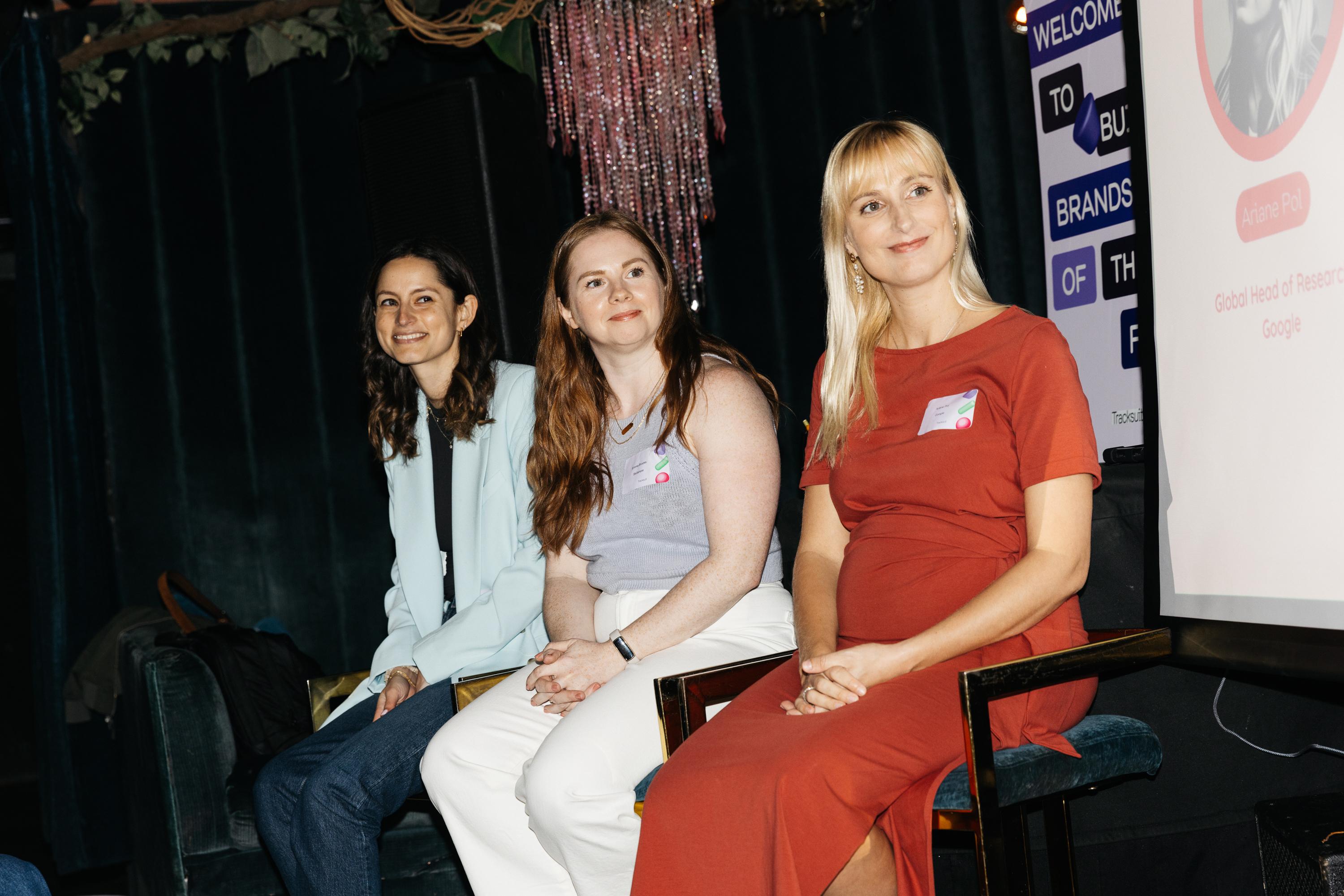 Three women, Ariane Pol from Google, Emma Brooks from Skillshare, and Allison Eatroff from Momofuku, sitting on a couch during the Building Brands of the Future event in NYC, discussing brand building and community development strategies in front of a projector screen