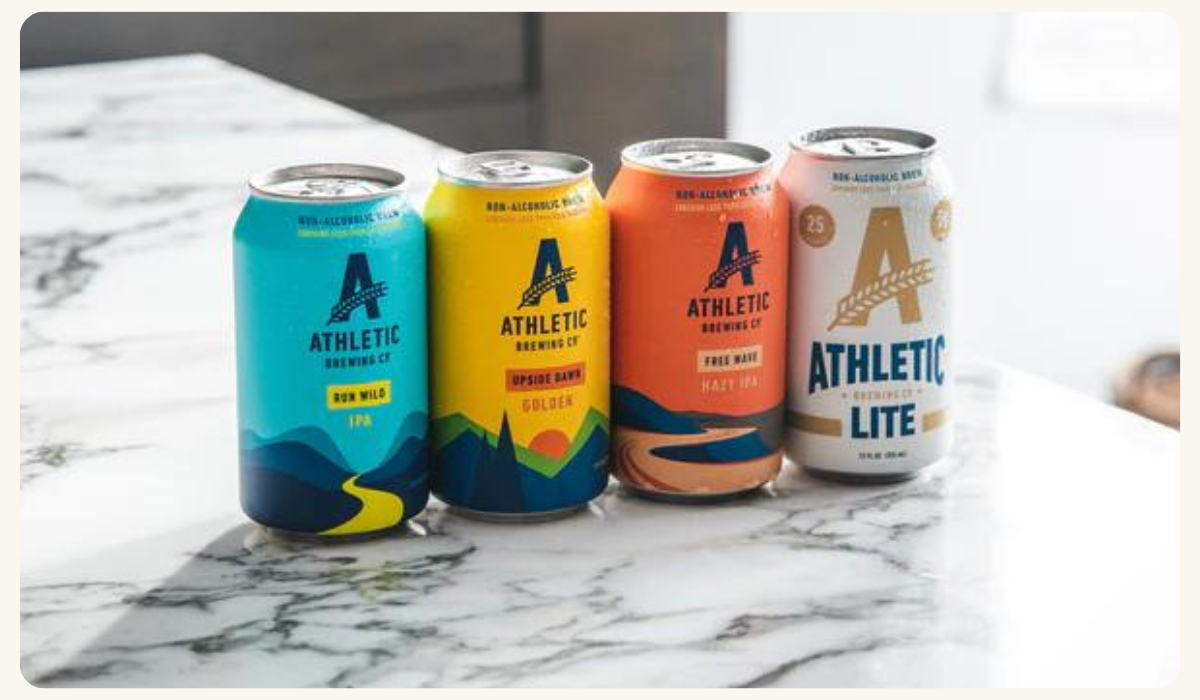 Four cans of Athletic Brewing Company's beer displayed on a counter, a brand monitored by Tracksuit, a marketing data and brand tracking solution company