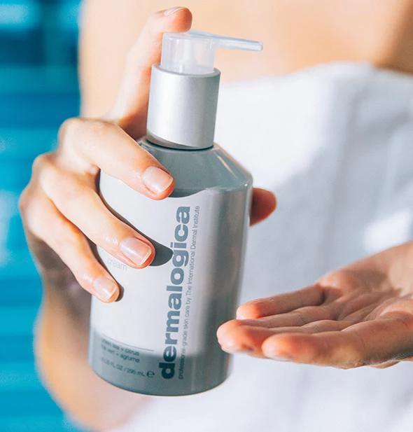 A woman holding a bottle of Dermalogica lotion, a premium skincare product from a brand known for its innovative, scientific, and modern approach to skincare.