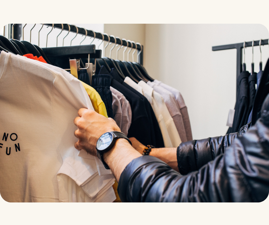 A customer browsing a shirt with the phrase 'no fun' printed on it in a retail store during peak sales season